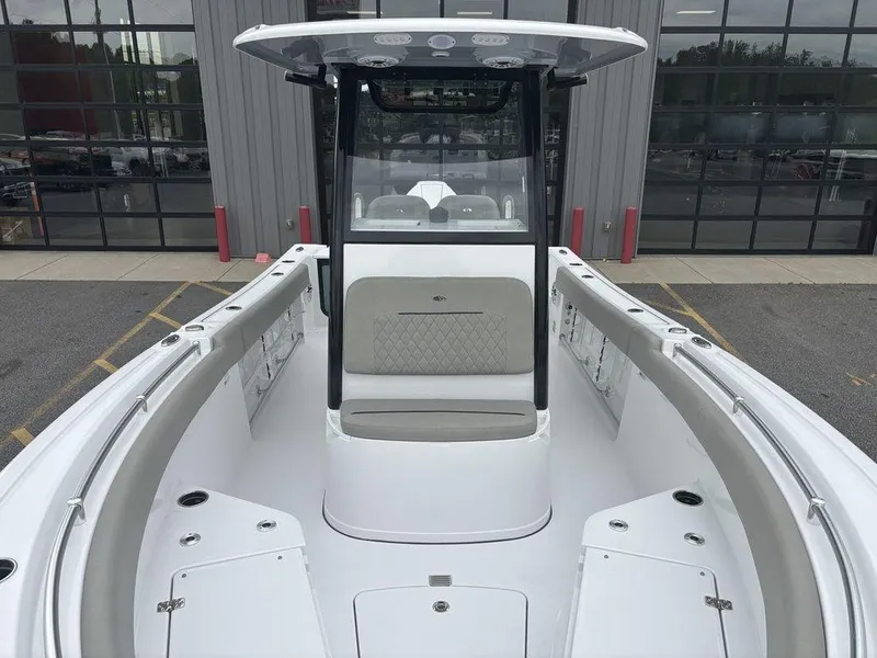 Slide: The Image of 2025 Sportsman Open 232 boat interior with seating and console, parked outdoors. - 22