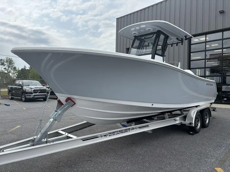 Slide: The Image of 2025 Sportsman Open 232 boat on trailer, parked outside a building. - 6