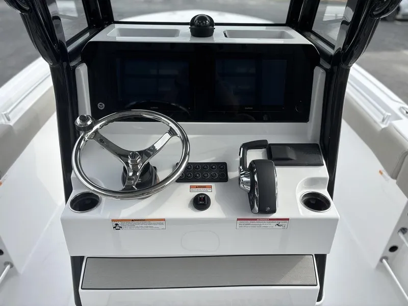 Slide: The Image of 2025 Sportsman Open 232 boat console with steering wheel and controls. - 8