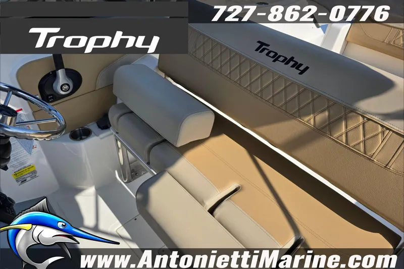 Slide: The Image of 2025 Trophy T22 SC boat interior with tan seating, cup holders, and contact details. - 59