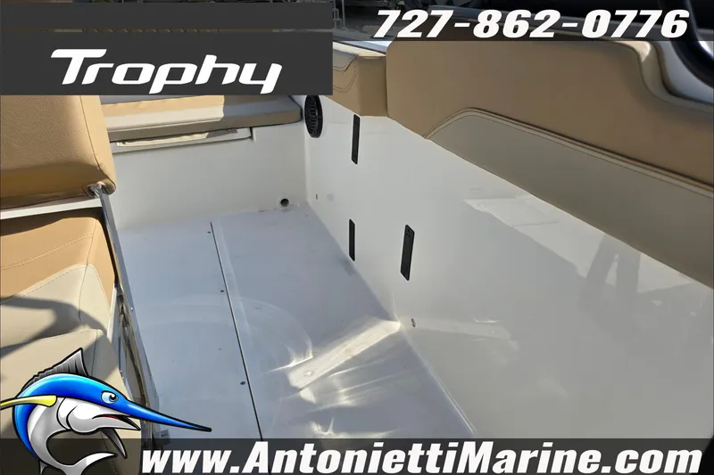 Slide: The Image of 2025 Trophy T22 SC boat interior with tan seating, displayed at a marina. - 77