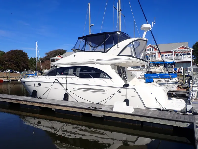 Slide: The Image of 2006 Meridian 411 Sedan yacht docked at marina under clear blue sky. - 2