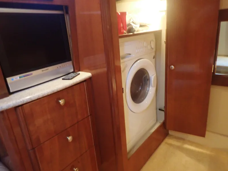 Slide: The Image of 2006 Meridian 411 Sedan interior with TV, washer, and wooden cabinetry. - 28