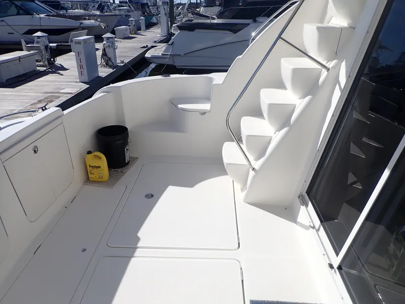Slide: The Image of 2006 Meridian 411 Sedan yacht deck with stairs and docked boats in background. - 6