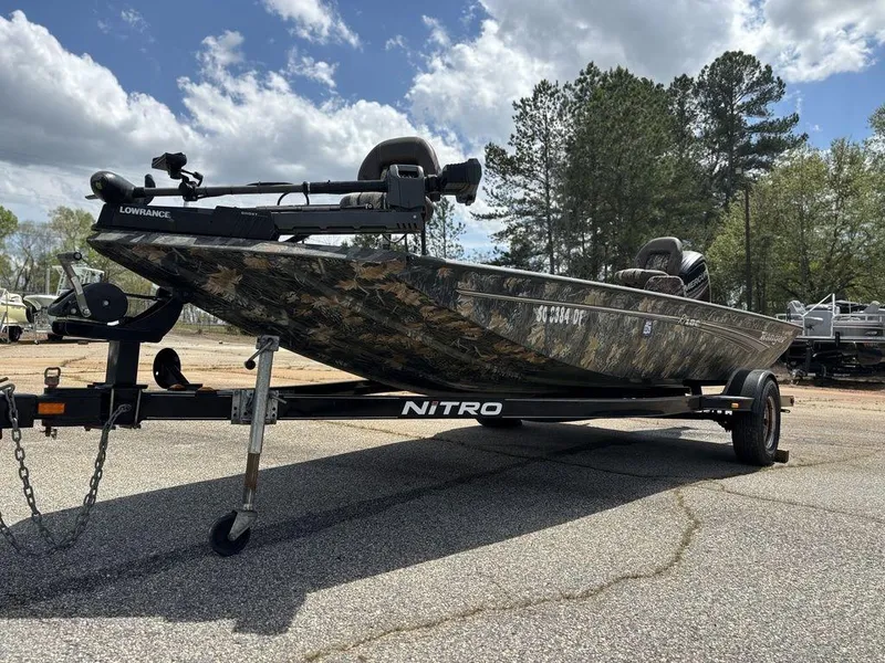 Slide: The Image of 2015 Ranger RC188 boat on Nitro trailer, camo design, parked outdoors under cloudy sky. - 12