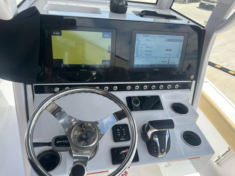 Slide: The Image of 2023 Sportsman Masters 247OE Bay Boat dashboard with dual screens and steering wheel. - 13