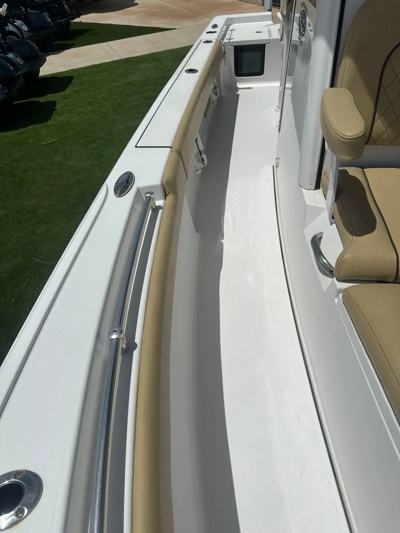 Slide: The Image of 2023 Sportsman Masters 247OE Bay Boat interior with tan seating and sleek white deck. - 14