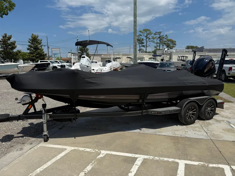Slide: The Image of 2023 Skeeter ZXR 20 boat covered on a trailer in a parking lot. - 28