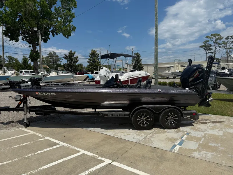 Slide: The Image of 2023 Skeeter ZXR 20 boat on trailer, parked outdoors under a partly cloudy sky. - 7