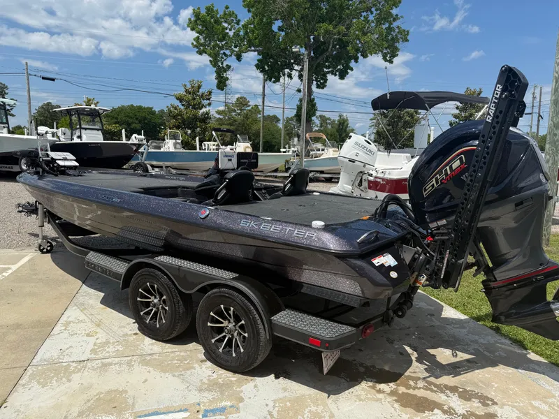 Slide: The Image of 2023 Skeeter ZXR 20 boat with powerful engine, parked on a trailer in a marina. - 8