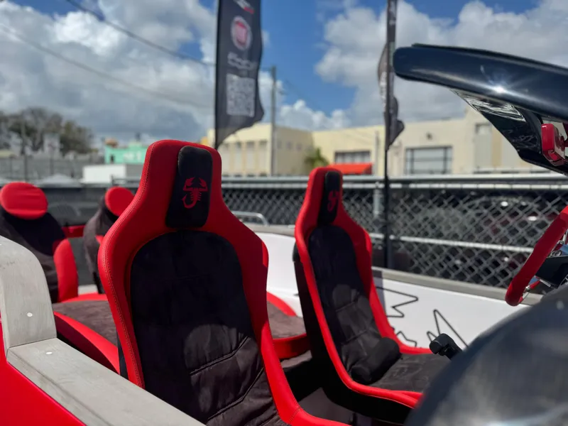 Slide: The Image of 2025 Car Off-shore Fiat 500 Abarth seats, red and black design, outdoor setting. - 7