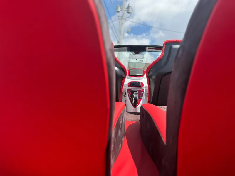 Slide: The Image of 2025 Fiat 500 Abarth interior with red and black seats, modern dashboard, and open roof. - 9