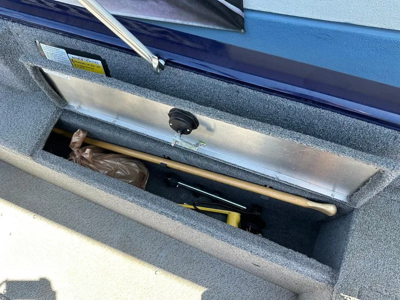 Slide: The Image of Storage compartment in a 2019 Tracker Pro Guide V-175 Combo boat, containing tools and equipment. - 40