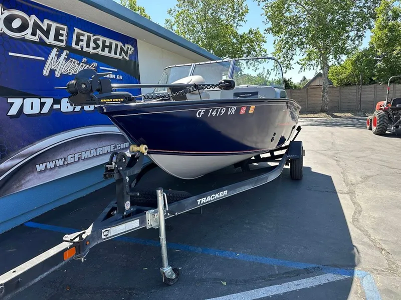 Slide: The Image of 2019 Tracker Pro Guide V-175 Combo boat on trailer, parked outdoors near a marine shop. - 5