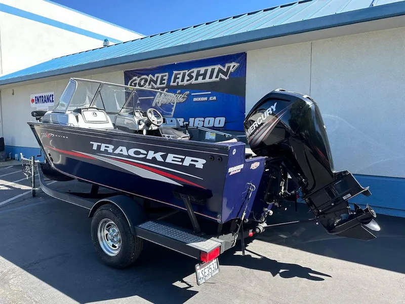 Slide: The Image of 2019 Tracker Pro Guide V-175 Combo boat on trailer, parked outside a fishing store. - 6