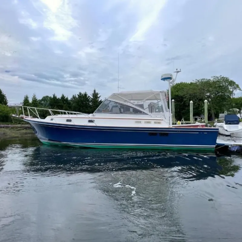The Image of 1997 Little Harbor WhisperJet 36 boat on water, blue hull, white deck, overcast sky. - 0