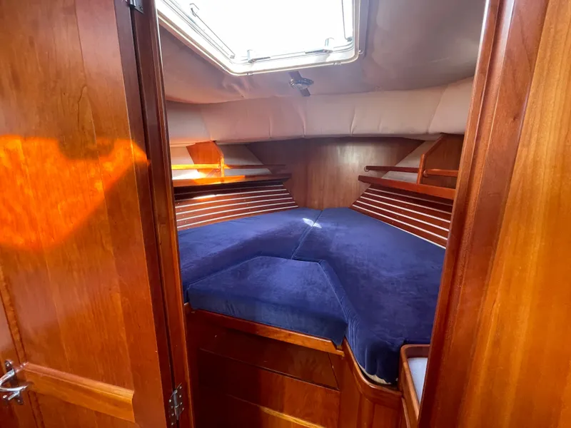 Slide: The Image of Interior cabin of 1997 Little Harbor WhisperJet 36 with blue bedding and wooden finish. - 12