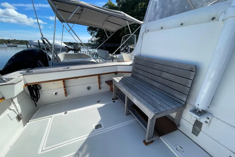 Slide: The Image of 1997 Little Harbor WhisperJet 36 boat deck with wooden bench and canopy, docked by the water. - 16