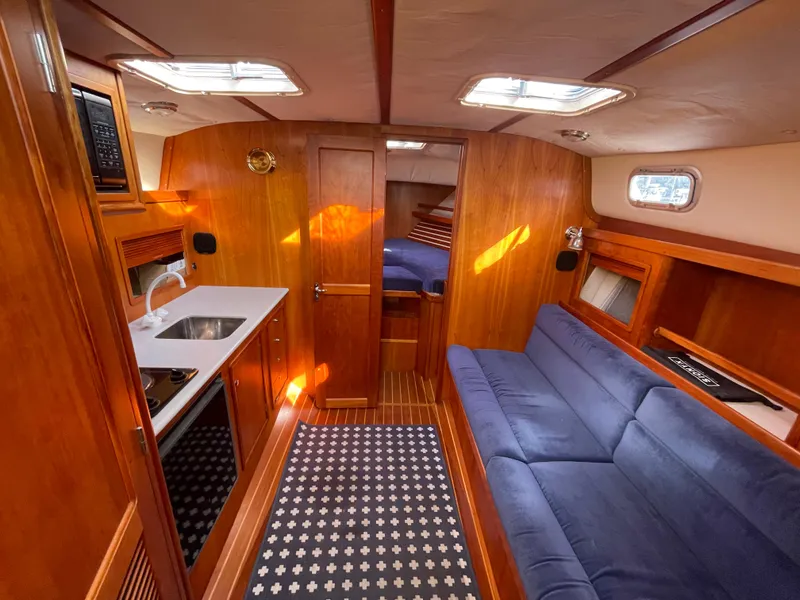 Slide: The Image of Interior of 1997 Little Harbor WhisperJet 36 yacht with wood finish and blue seating. - 7