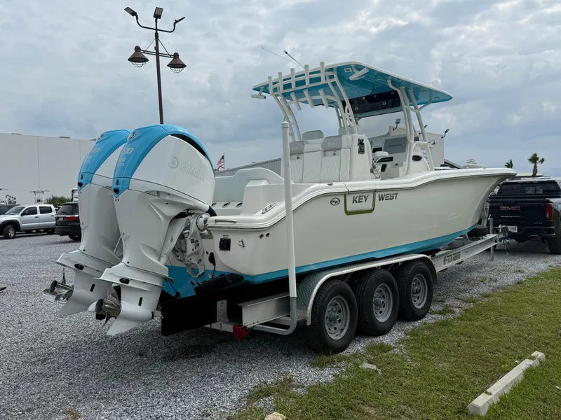 Slide: The Image of 2024 Key West 291 FS boat on trailer with dual engines, parked outdoors. - 3
