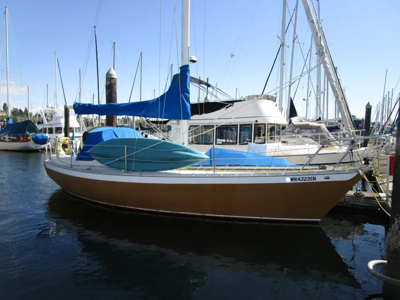 Slide: The Image of 1974 Irwin Competition 30 sailboat docked in a marina, featuring blue covers and sails. - 3