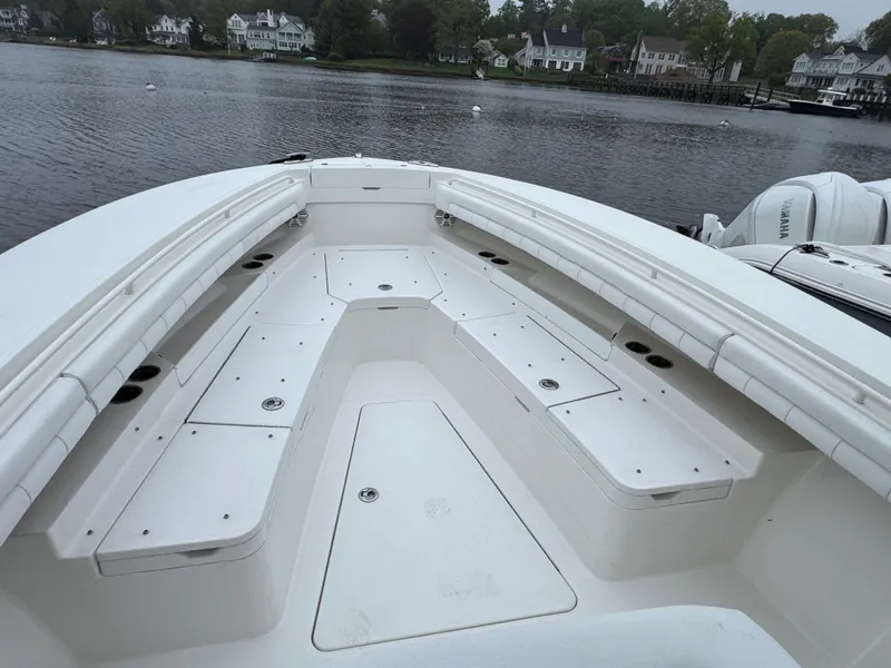 Slide: The Image of 2019 Regulator 31 boat with spacious seating, docked by a serene waterfront. - 18