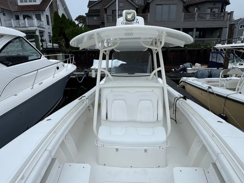 Slide: The Image of 2019 Regulator 31 boat docked, featuring a spacious white deck and seating area. - 4