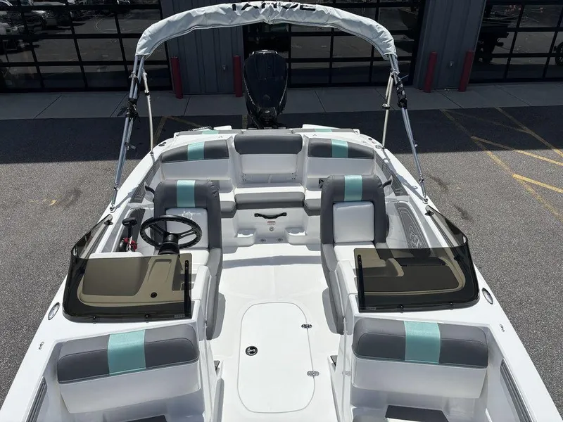 Slide: The Image of 2025 Tahoe T21 boat interior with seating and steering wheel, docked outdoors. - 13