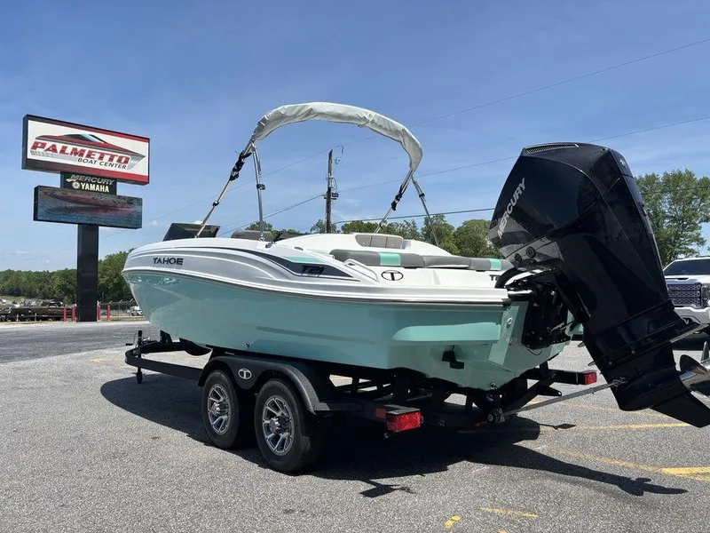 Slide: The Image of 2025 Tahoe T21 boat on trailer, parked outdoors, with outboard motor and canopy. - 5