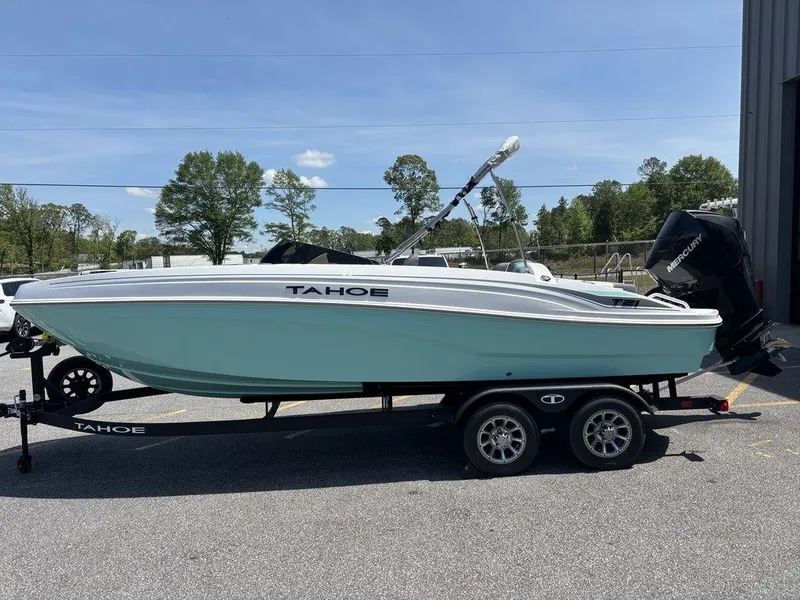 Slide: The Image of 2025 Tahoe T21 boat on trailer, light blue hull, parked outdoors. - 6