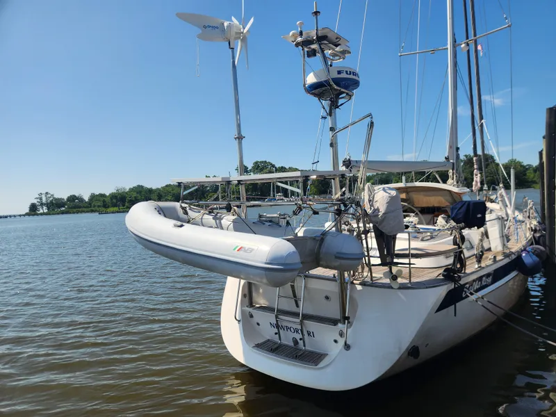 Slide: The Image of Sailing yacht Hallberg-Rassy 48 (2006) docked with inflatable dinghy, clear sky, and calm waters. - 10
