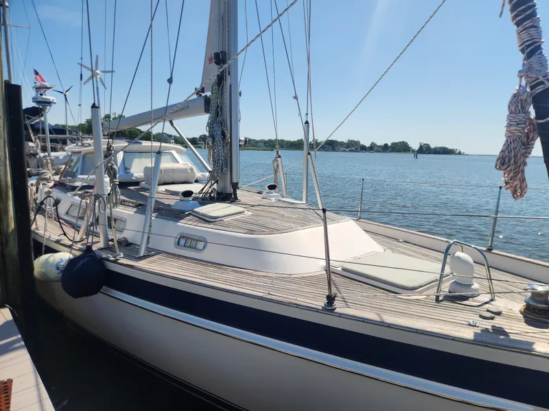 Slide: The Image of Sailing yacht Hallberg-Rassy 48, 2006 model, docked by the water on a sunny day. - 12