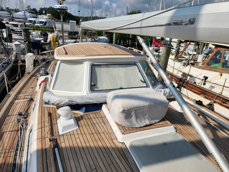 Slide: The Image of 2006 Hallberg-Rassy 48 sailboat docked, showcasing teak deck and covered cockpit. - 18