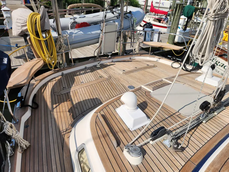 Slide: The Image of Teak deck of 2006 Hallberg-Rassy 48 sailboat, featuring rigging and equipment at a marina. - 22