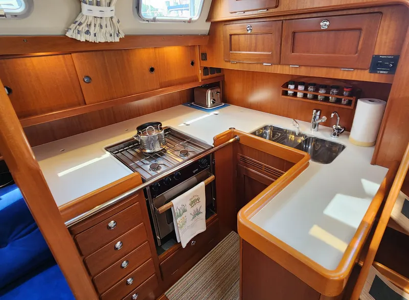 Slide: The Image of Luxurious 2006 Hallberg-Rassy 48 yacht kitchen with wooden cabinetry and modern appliances. - 28