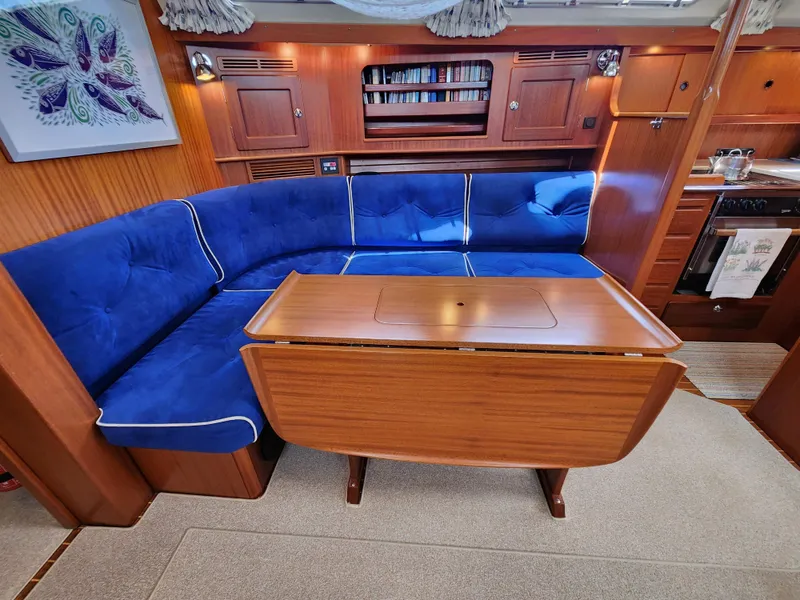 Slide: The Image of Luxurious 2006 Hallberg-Rassy 48 yacht interior with blue seating and wooden table. - 29