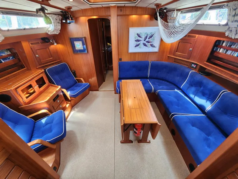 Slide: The Image of Luxurious 2006 Hallberg-Rassy 48 yacht interior with blue seating and wooden finishes. - 30