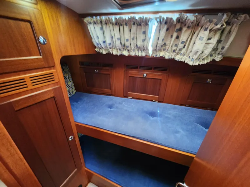 Slide: The Image of Interior cabin of 2006 Hallberg-Rassy 48 yacht with wooden finish and blue upholstery. - 32