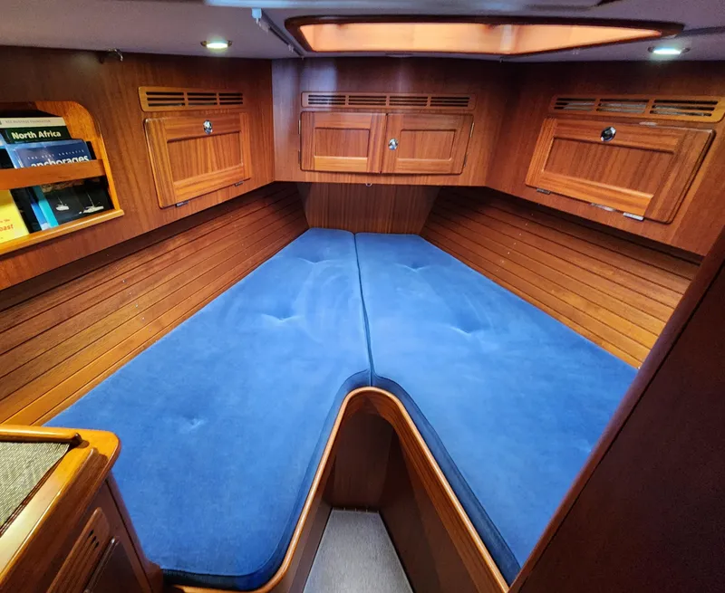 Slide: The Image of Interior cabin of 2006 Hallberg-Rassy 48 yacht with blue cushions and wooden finish. - 36