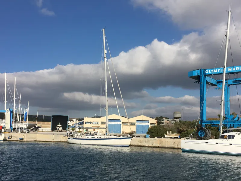 Slide: The Image of Sailboats docked at a marina, featuring a 2006 Hallberg-Rassy 48 under a partly cloudy sky. - 4