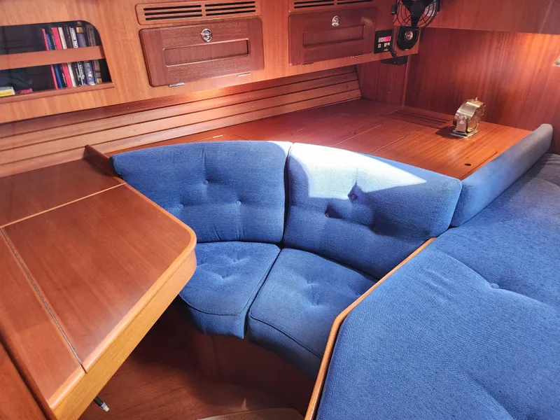Slide: The Image of Interior of 2006 Hallberg-Rassy 48 yacht with blue cushioned seating and wooden cabinetry. - 40