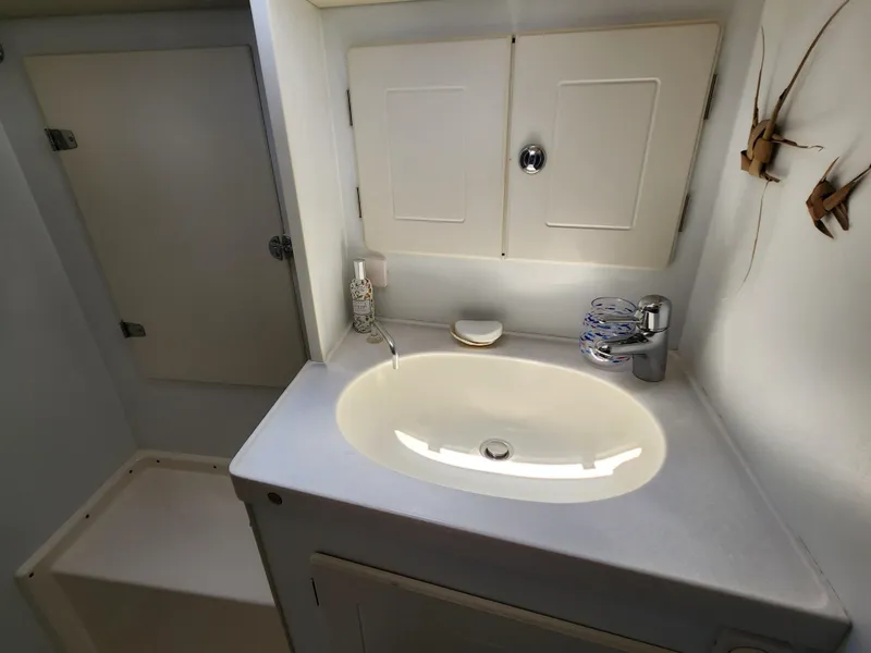 Slide: The Image of Hallberg-Rassy 48 (2006) yacht bathroom with sink, faucet, and storage cabinets. - 47