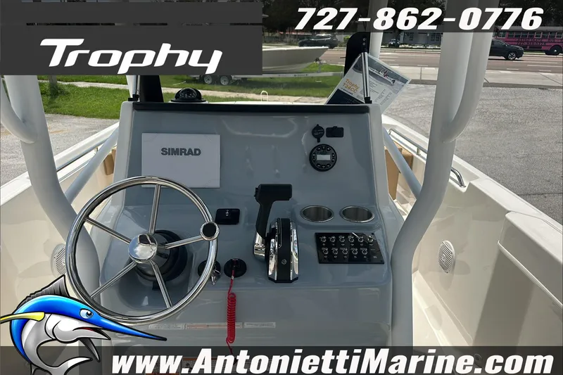 Slide: The Image of 2025 Trophy T24 CC boat dashboard with steering wheel and controls, featuring Simrad electronics. - 14