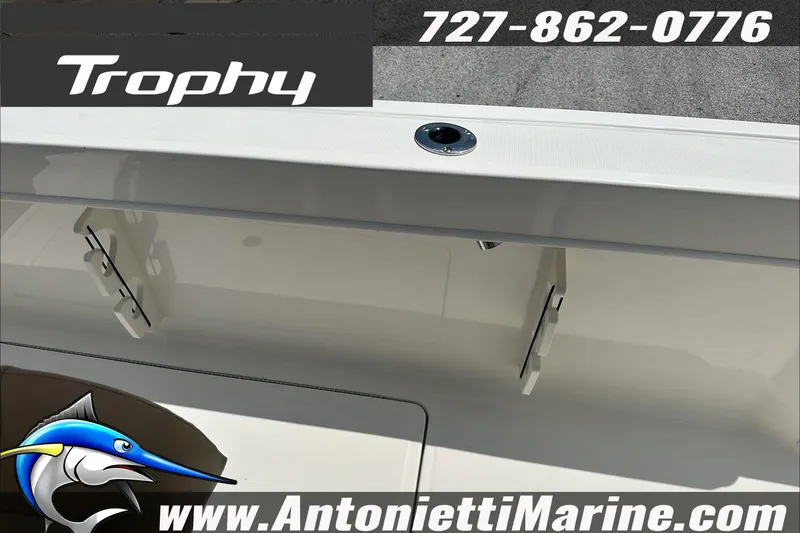 Slide: The Image of 2025 Trophy T24 CC boat interior with storage compartments, contact info, and logo. - 19