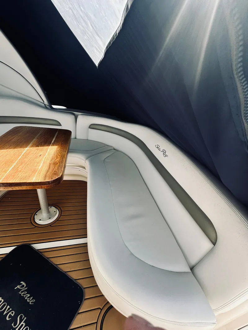 Slide: The Image of 2006 Sea Ray 320 Sundancer interior with wooden table and cushioned seating. - 11