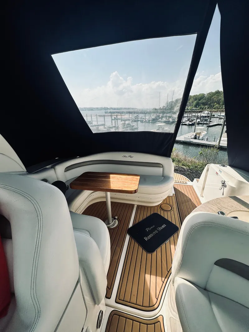 Slide: The Image of 2006 Sea Ray 320 Sundancer interior with wood accents, marina view, and comfortable seating. - 15