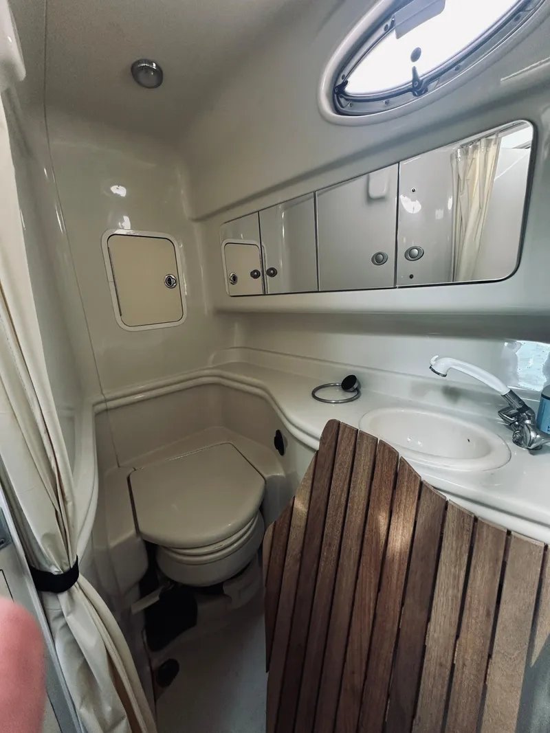 Slide: The Image of 2006 Sea Ray 320 Sundancer bathroom with sink, toilet, and wooden accents. - 18