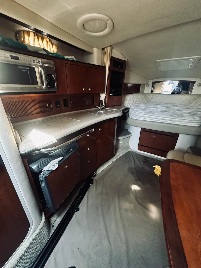 Slide: The Image of Interior of 2006 Sea Ray 320 Sundancer yacht with kitchenette and sleeping area. - 21