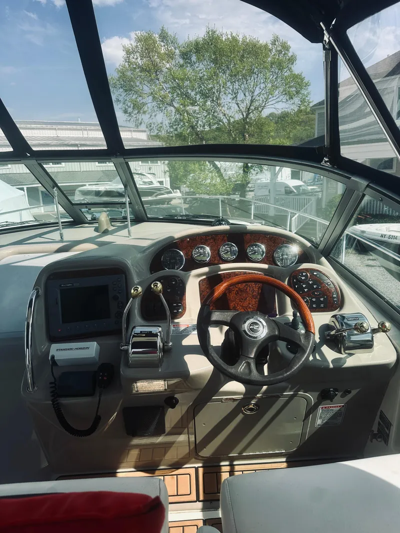Slide: The Image of 2006 Sea Ray 320 Sundancer helm with gauges, steering wheel, and navigation equipment. - 25