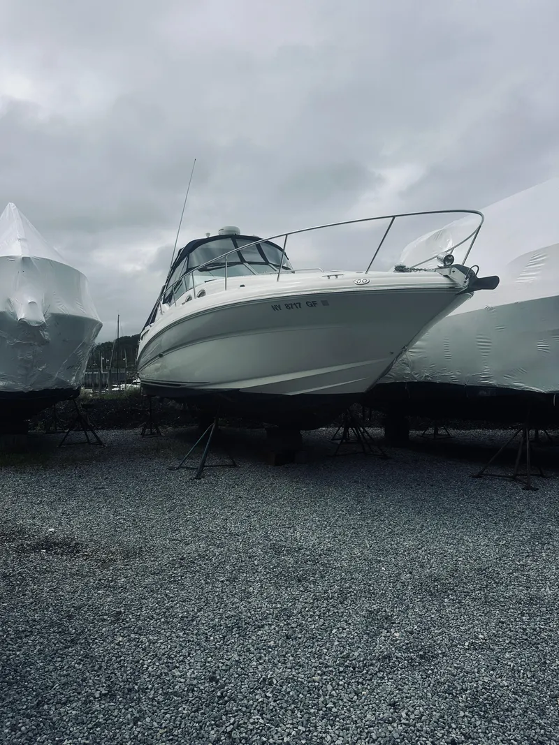 Slide: The Image of 2006 Sea Ray 320 Sundancer boat on gravel, overcast sky. - 4